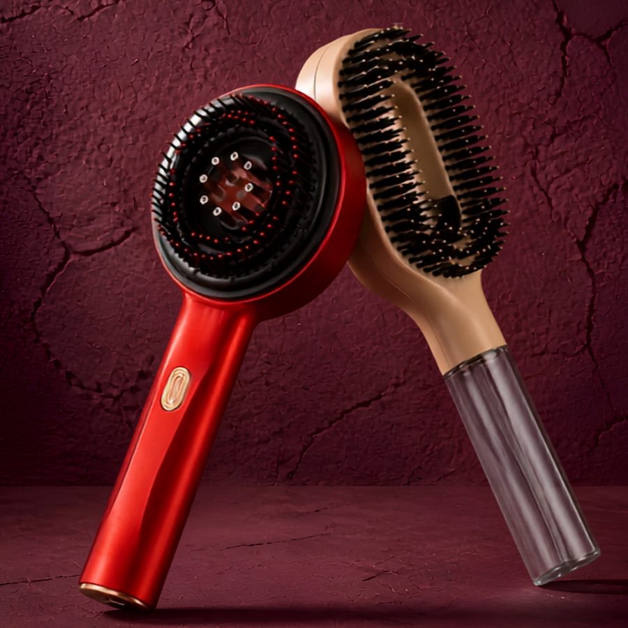 The Laser Red Light Therapy Comb and the 2-in-1 Hair Mist Brush leaning together against a deep burgundy backdrop